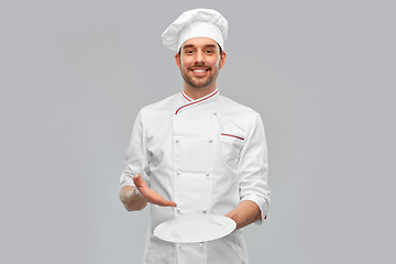 Image showing happy smiling male chef holding empty plate