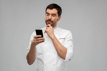 Image showing thinking male chef with smartphone