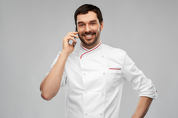 Image showing happy smiling male chef calling on smartphone