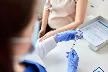 Image showing female doctor with syringe vaccinating patient