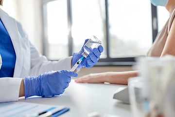 Image showing female doctor with syringe vaccinating patient