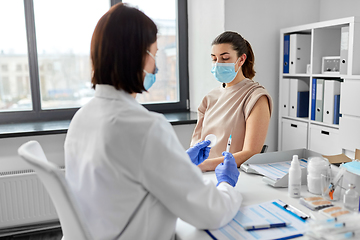 Image showing female doctor with syringe vaccinating patient