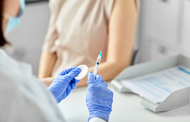 Image showing female doctor with syringe vaccinating patient