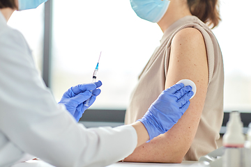 Image showing female doctor with syringe vaccinating patient