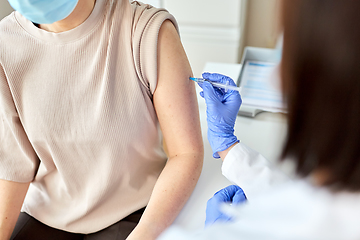 Image showing female doctor with syringe vaccinating patient