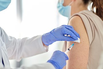 Image showing female doctor with syringe vaccinating patient