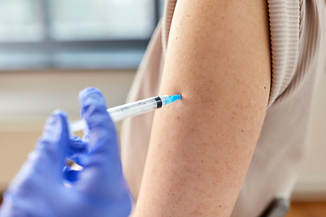 Image showing close up of hand with syringe vaccinating patient