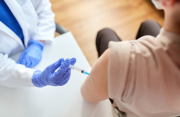 Image showing doctor with syringe vaccinating patient