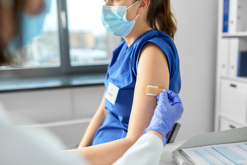 Image showing doctor attaching patch to medical worker