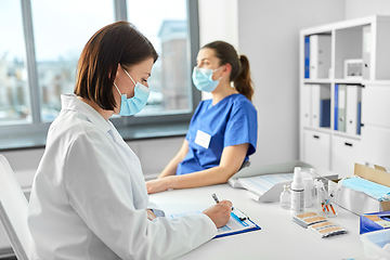 Image showing doctor with clipboard and nurse at hospital