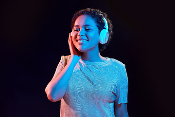 Image showing woman in headphones listening to music and dancing