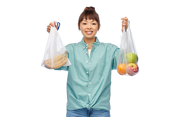 Image showing woman with fruits in reusable and plastic bags