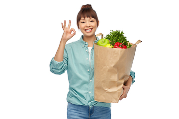 Image showing happy asian woman with food in paper shopping bag