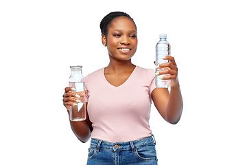 Image showing happy woman with plastic and glass bottle of water