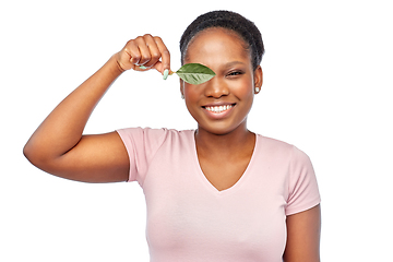 Image showing smiling african american woman holding green leaf