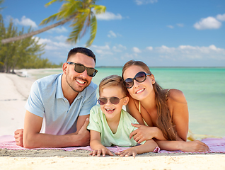 Image showing happy family lying over tropical beach background