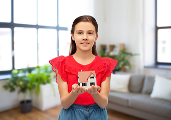 Image showing smiling girl holding house model at home