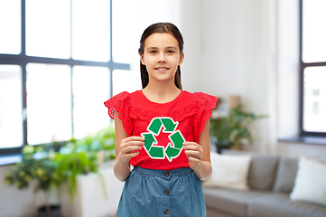 Image showing smiling girl holding green recycling sign at home