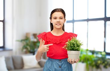 Image showing happy smiling girl holding flower in pot at home