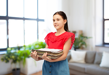 Image showing girl with magazines sorting paper waste at home