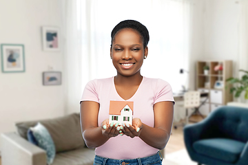 Image showing smiling african american woman holding house model