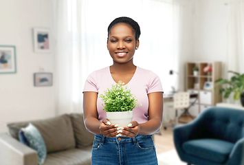 Image showing happy smiling african woman holding flower in pot