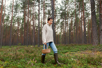 Image showing woman with basket picking mushrooms in forest