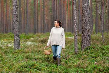 Image showing woman with basket picking mushrooms in forest