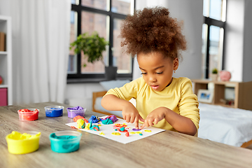 Image showing little girl with modeling clay playing at home