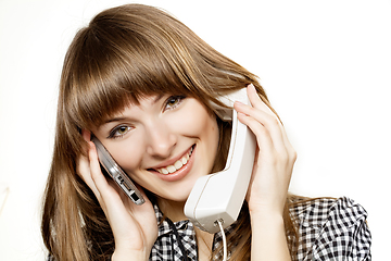 Image showing Portrait of a young secretary talking on phone with two persons at the same time