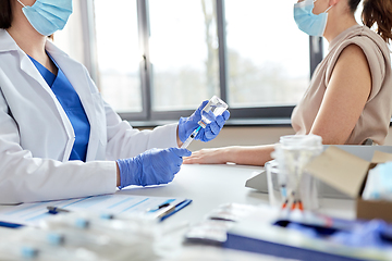 Image showing female doctor with syringe vaccinating patient