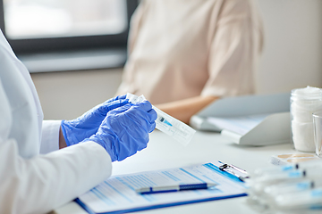 Image showing female doctor with syringe and patient at hospital