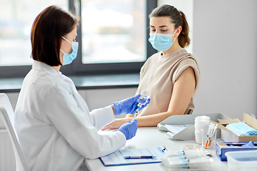 Image showing female doctor with syringe vaccinating patient