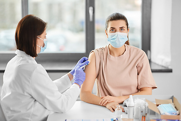 Image showing female doctor with syringe vaccinating patient