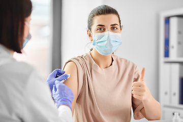 Image showing female doctor with syringe vaccinating patient