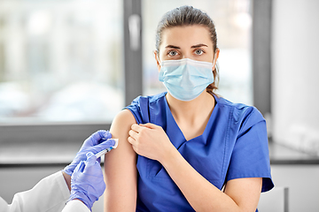 Image showing doctor with syringe vaccinating medical worker