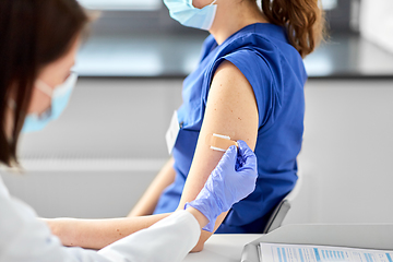 Image showing doctor attaching patch to medical worker