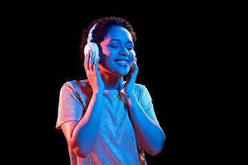 Image showing woman in headphones listening to music and dancing