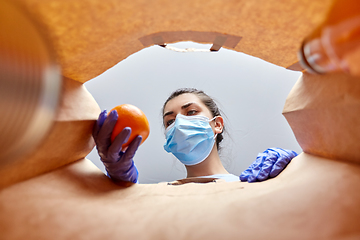 Image showing woman in gloves and mask with food in paper bag