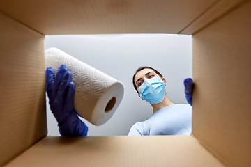 Image showing woman in mask taking cleaning supplies from box