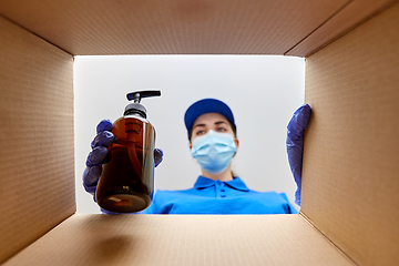 Image showing woman in mask packing parcel box with cosmetics