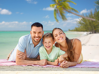 Image showing happy family lying over tropical beach background