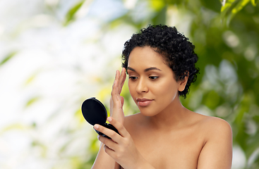 Image showing african american woman looking to mirror