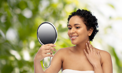 Image showing smiling african american woman looking to mirror