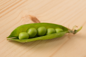 Image showing Fresh green peas on a wooden table