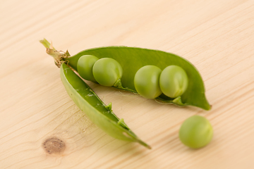 Image showing Fresh green peas on a wooden table
