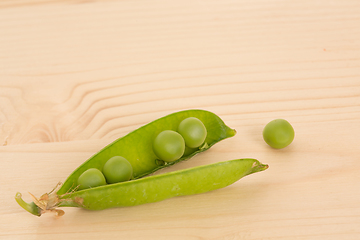 Image showing Fresh green peas on a wooden table