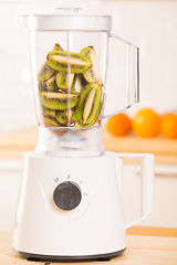 Image showing White blender with Kiwi on a wooden table