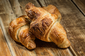 Image showing Two freshly baked croissants on wooden table