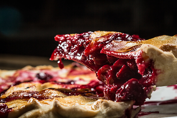 Image showing Tasty homemade pie with cherries on table close up